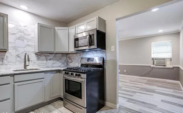 a kitchen with stainless steel appliances granite countertop a stove microwave and sink