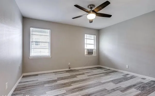 a view of a bedroom with a ceiling fan and a window