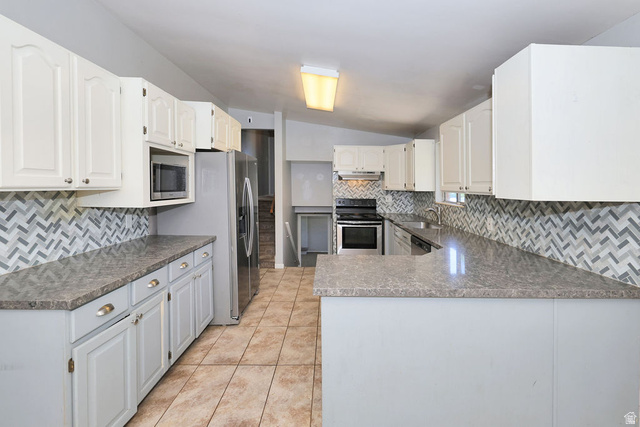 1272 Cook Street Ogden, UT 84404 - Photo 9 of 46 Kitchen featuring a multi-tone chevron tile backsplash, light-colored countertops, stainless steel appliances, white upper cabinetry, and light gray lower cabinetry