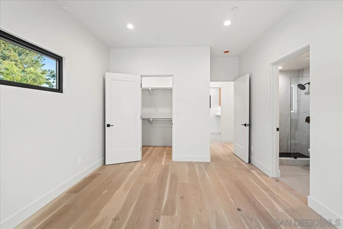 1009 Arcadia Road Encinitas, CA 92024 - Photo 26 of 37 a view of a hallway with wooden floor and a bathroom