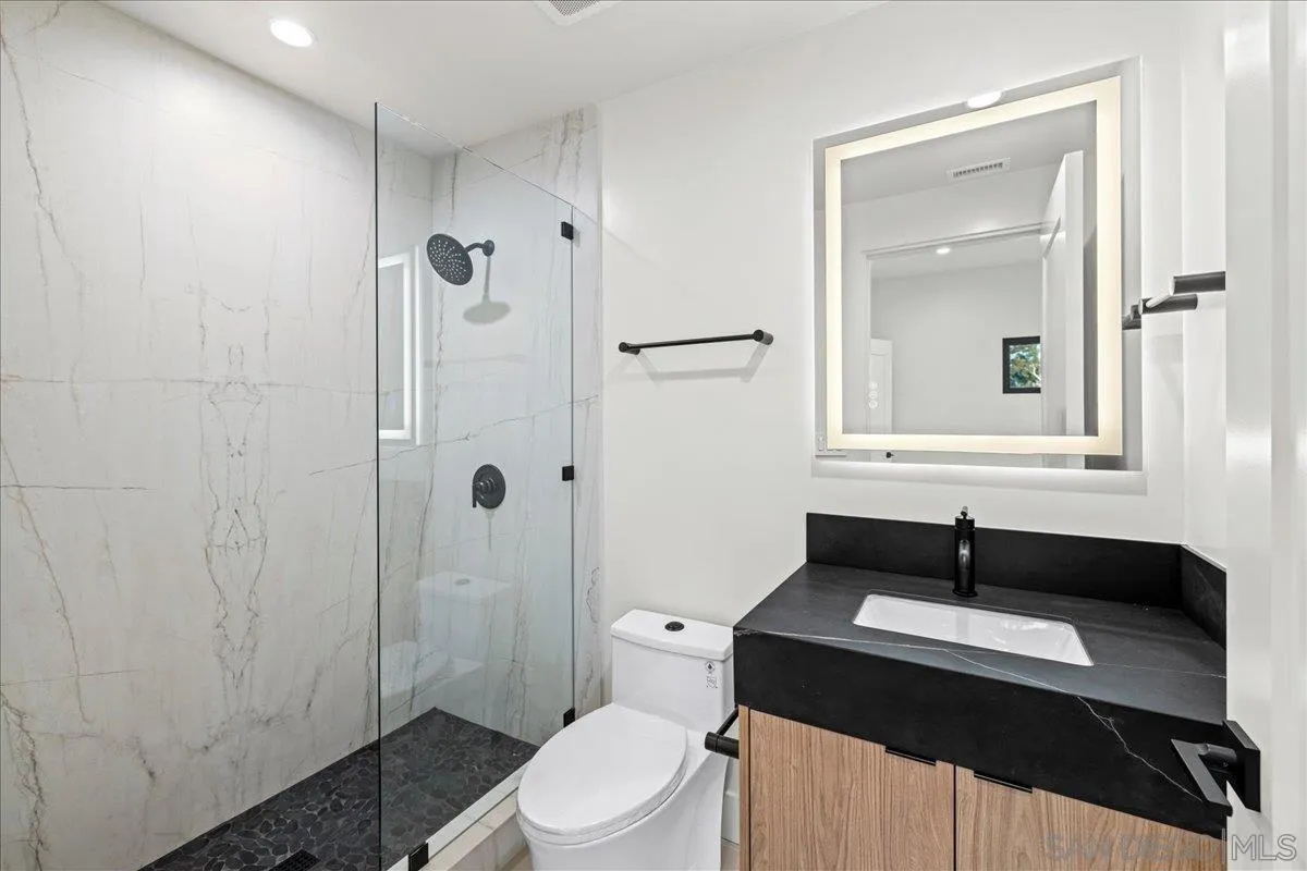 1009 Arcadia Road Encinitas, CA 92024 - Photo 27 of 37 a bathroom with a sink a toilet a shower and a mirror