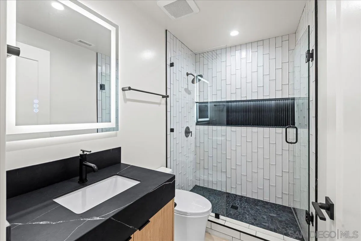 1009 Arcadia Road Encinitas, CA 92024 - Photo 30 of 37 a bathroom with a sink a toilet a mirror and shower