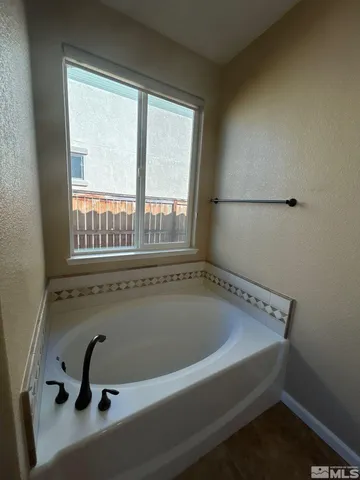 a bathroom with a tub and a window