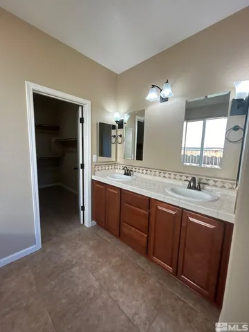 a spacious bathroom with a granite countertop sink and a mirror