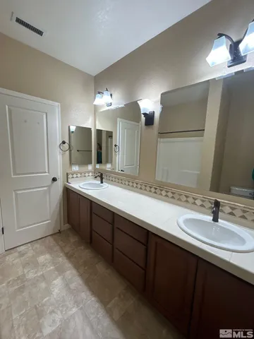 a bathroom with a double vanity sink a and a mirror