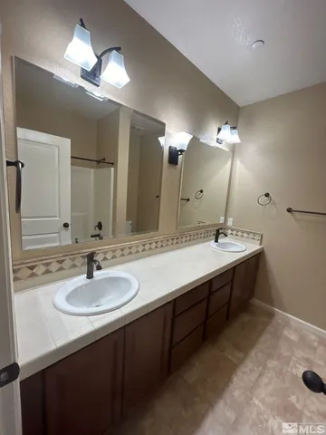 a bathroom with a sink double vanity and a mirror