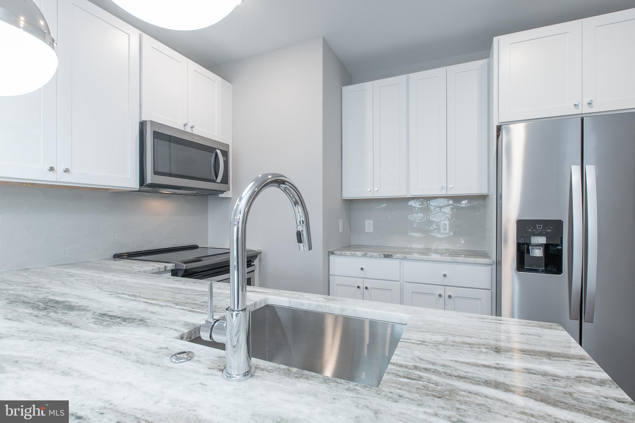 45 West Haines Street, Unit 303 Philadelphia, PA 19144 - Photo 16 of 24 a kitchen with stainless steel appliances granite countertop a refrigerator sink and stove