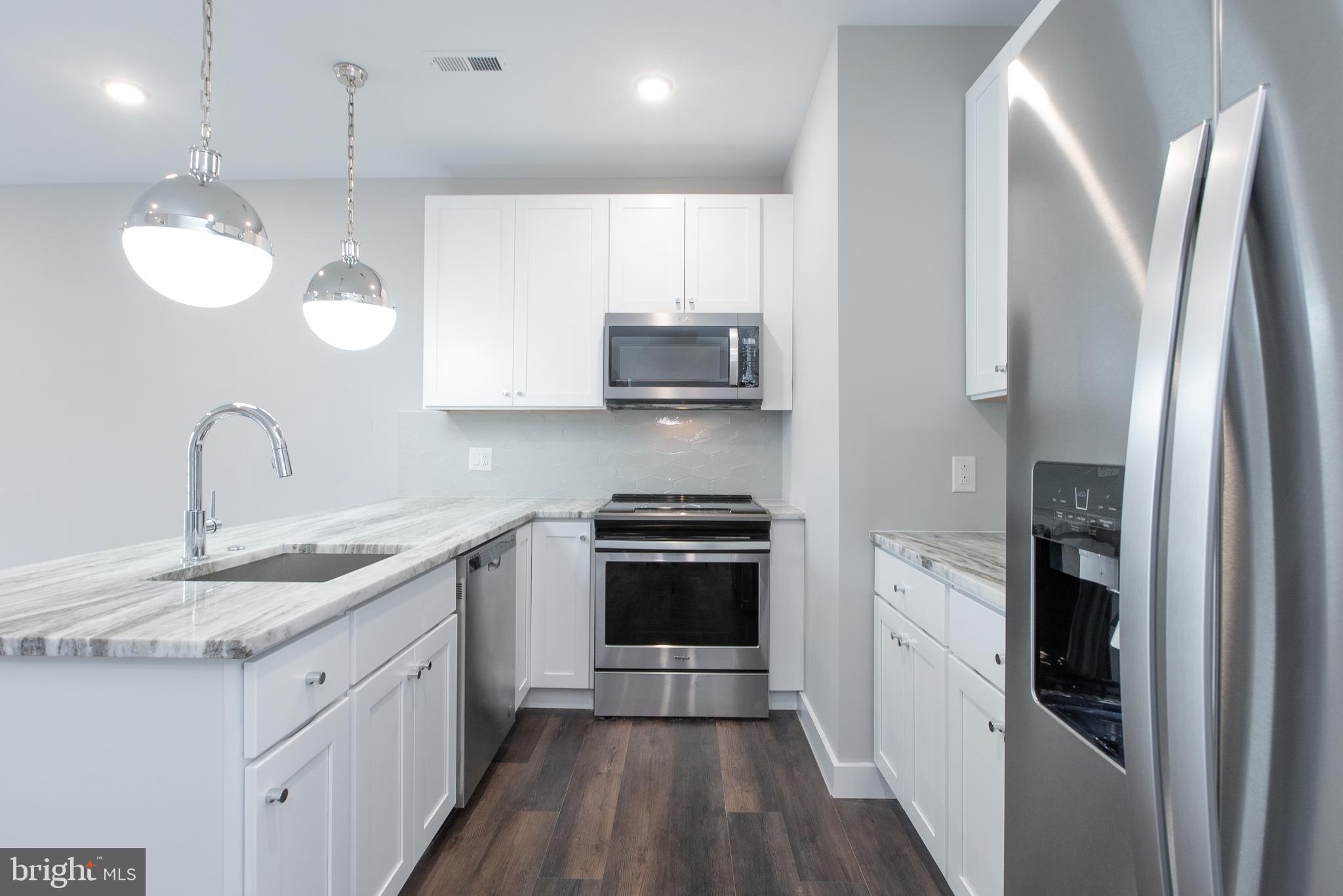 45 West Haines Street, Unit 303 Philadelphia, PA 19144 - Photo 17 of 24 a kitchen with stainless steel appliances granite countertop a sink stove and refrigerator
