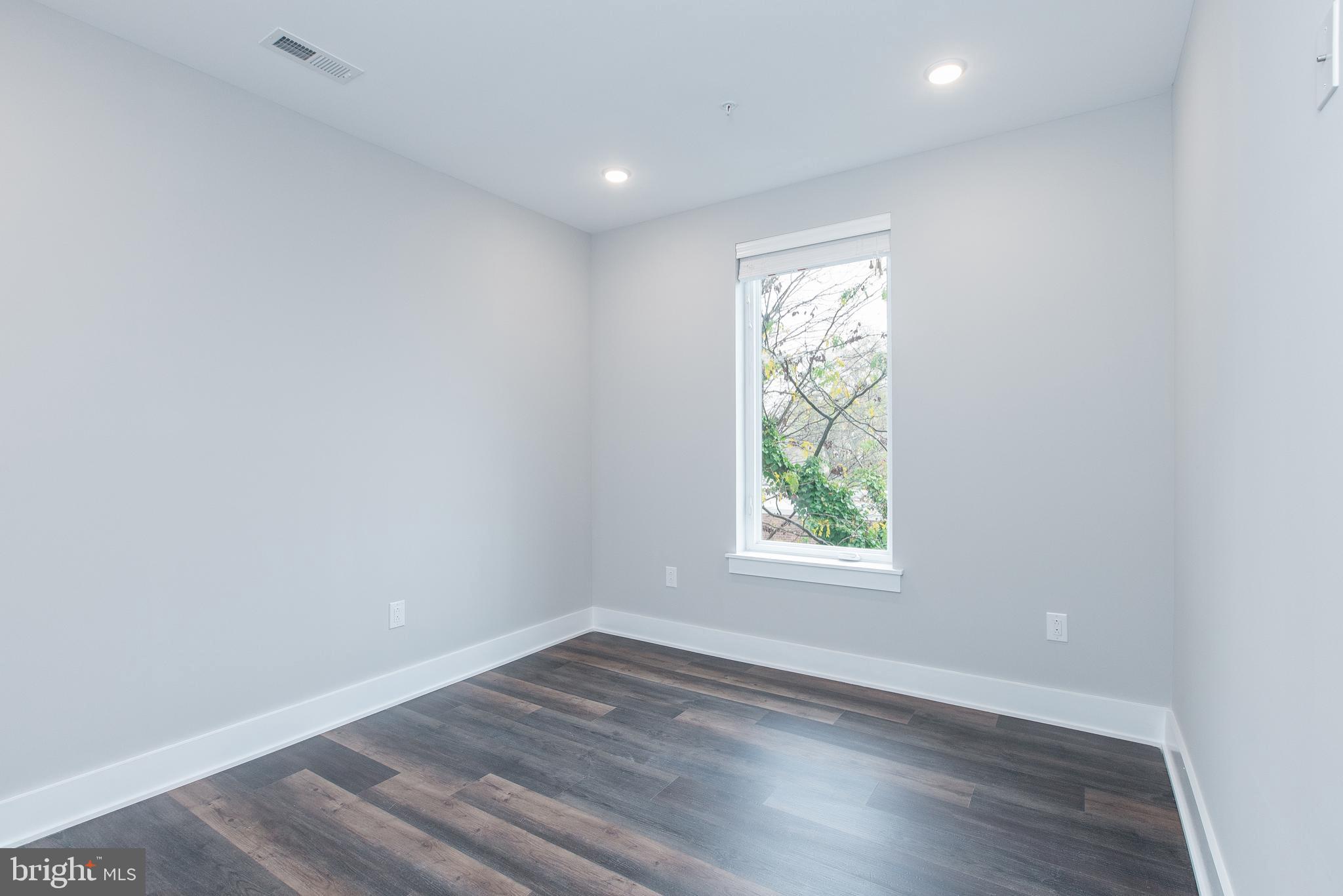 45 West Haines Street, Unit 303 Philadelphia, PA 19144 - Photo 19 of 24 an empty room with wooden floor and windows