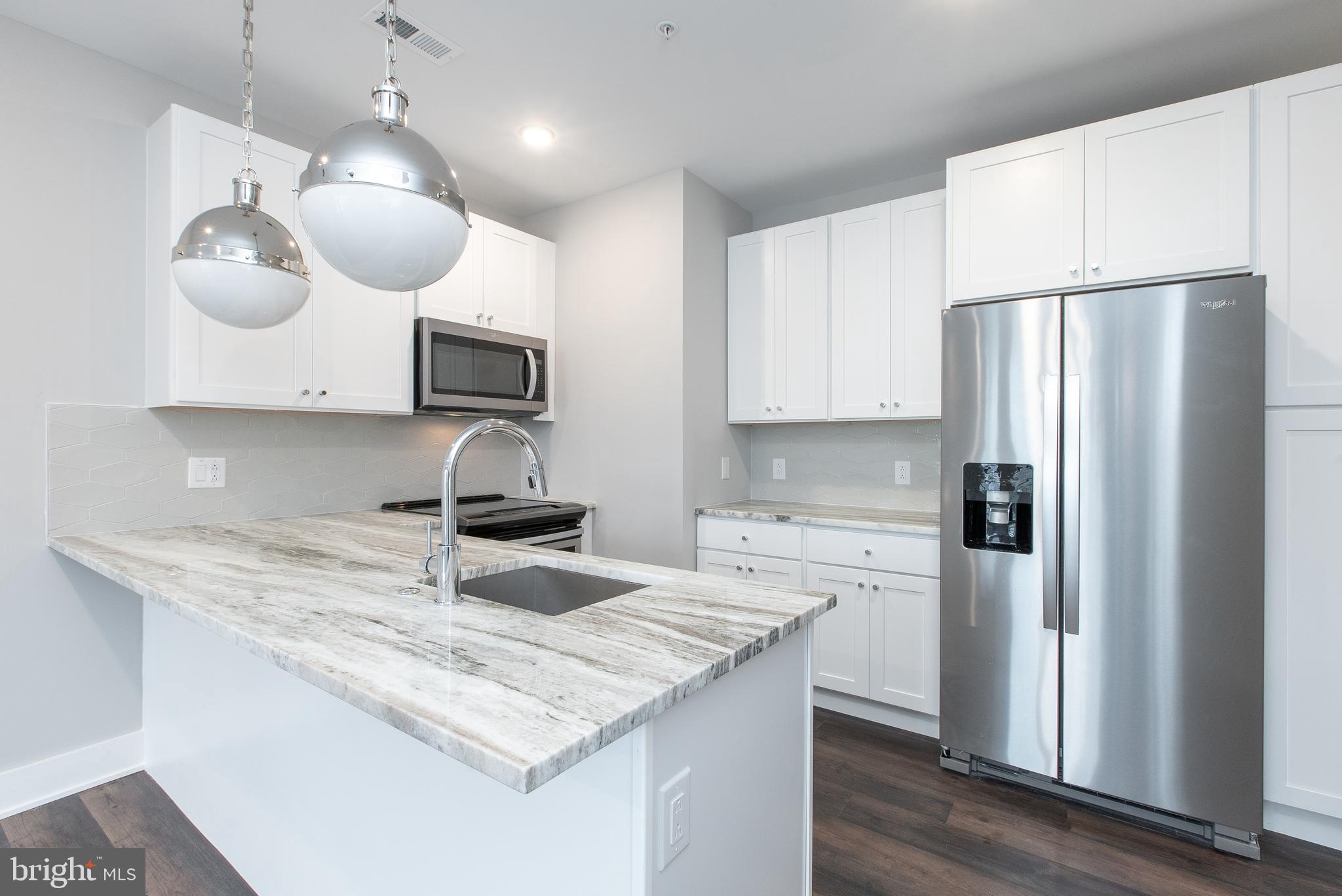 45 West Haines Street, Unit 303 Philadelphia, PA 19144 - Photo 4 of 24 a kitchen with stainless steel appliances granite countertop a sink refrigerator and microwave