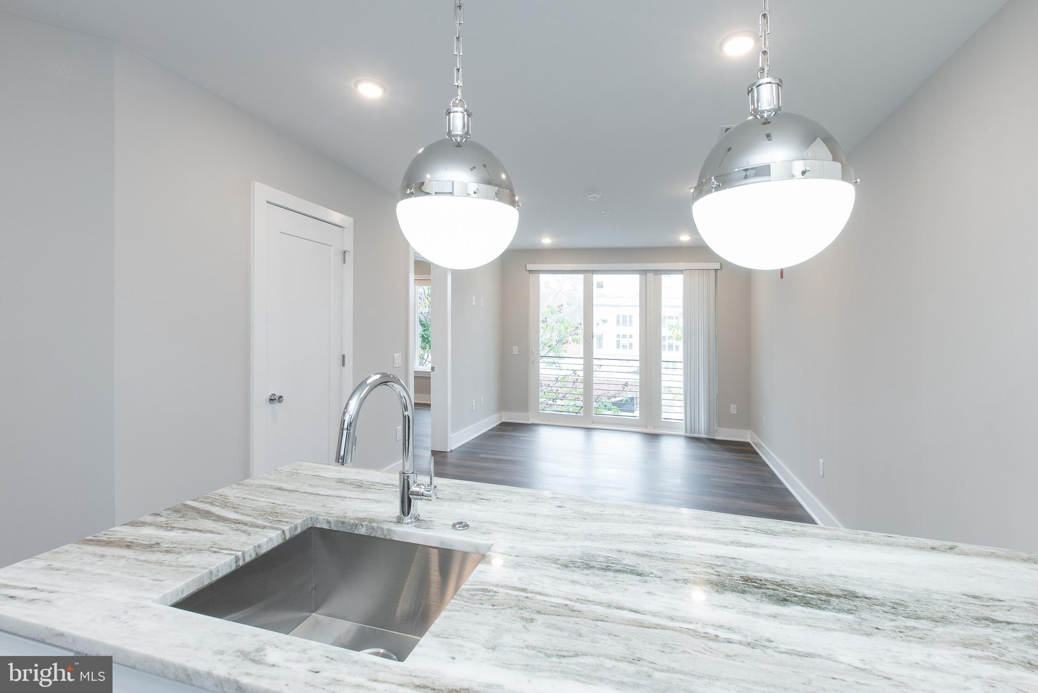 45 West Haines Street, Unit 303 Philadelphia, PA 19144 - Photo 5 of 24 a kitchen with kitchen island a sink and a stove