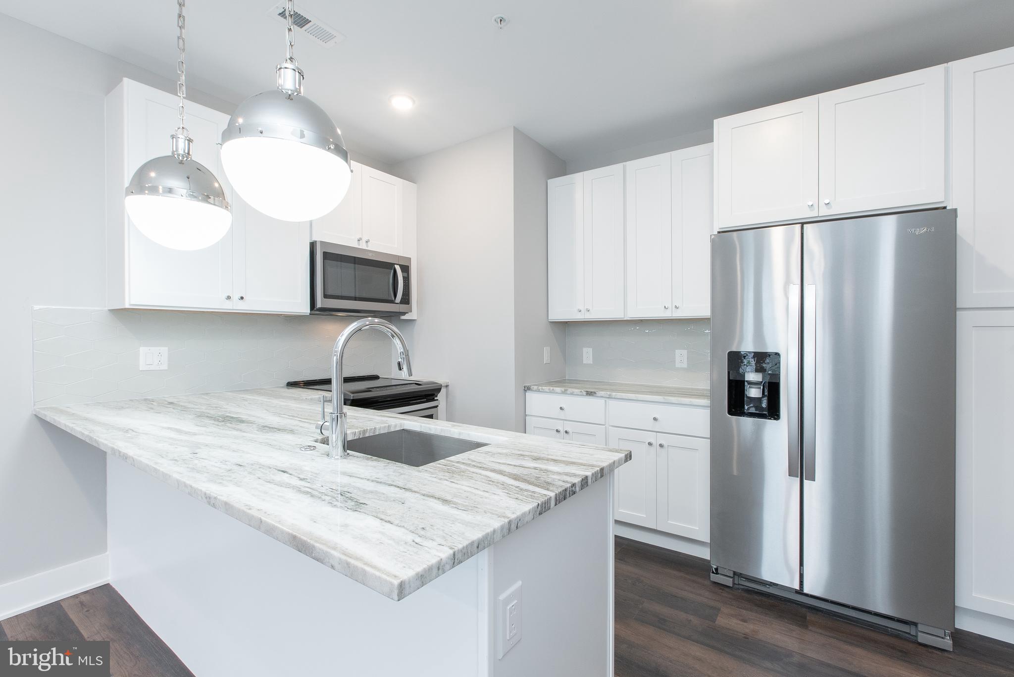 45 West Haines Street, Unit 303 Philadelphia, PA 19144 - Photo 6 of 24 a kitchen with stainless steel appliances granite countertop a sink refrigerator and microwave