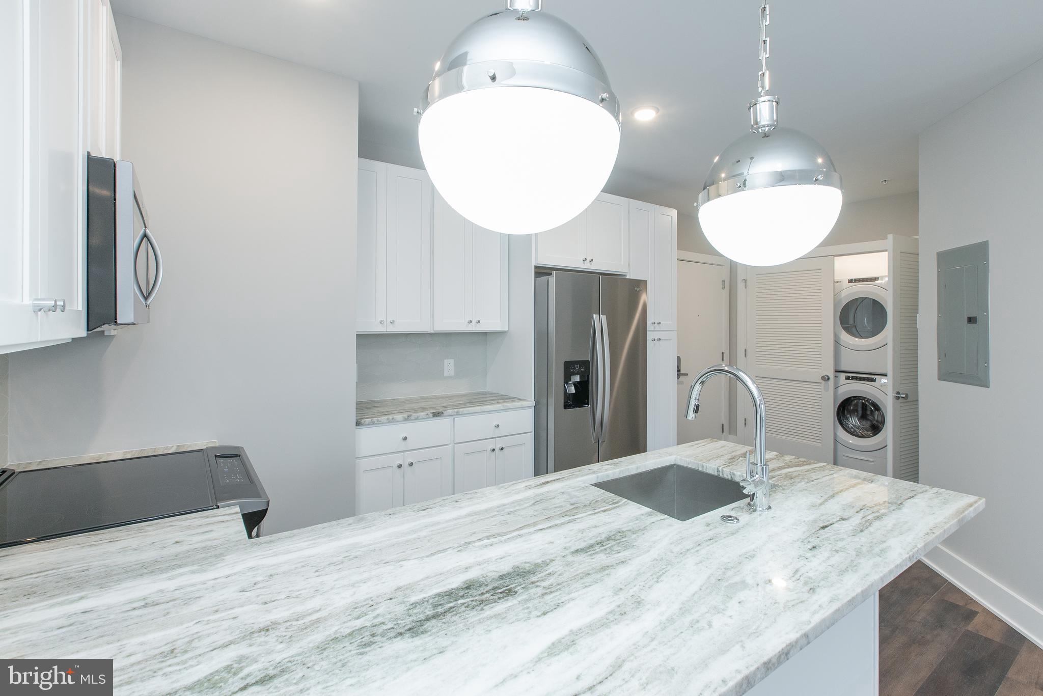 45 West Haines Street, Unit 303 Philadelphia, PA 19144 - Photo 8 of 24 a kitchen with stainless steel appliances kitchen island a refrigerator sink and fireplace