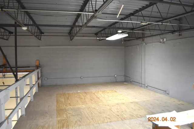 a view of an empty room with wooden floor and stairs