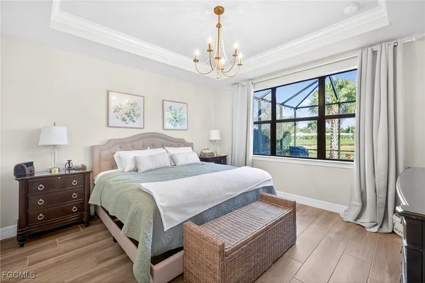 a bedroom with a large bed and a chandelier