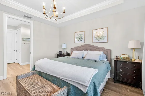 a bedroom with a bed and a lamp on dresser