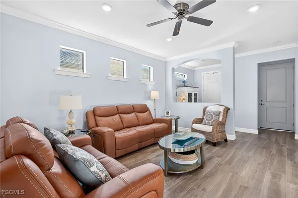 a living room with furniture and view of kitchen