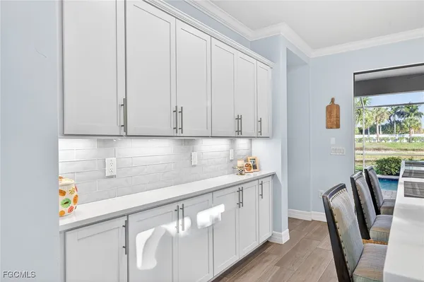 a kitchen with stainless steel appliances granite countertop a refrigerator a sink a stove with white cabinets