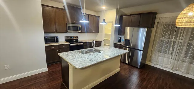 a view of a kitchen with a sink and a refrigerator
