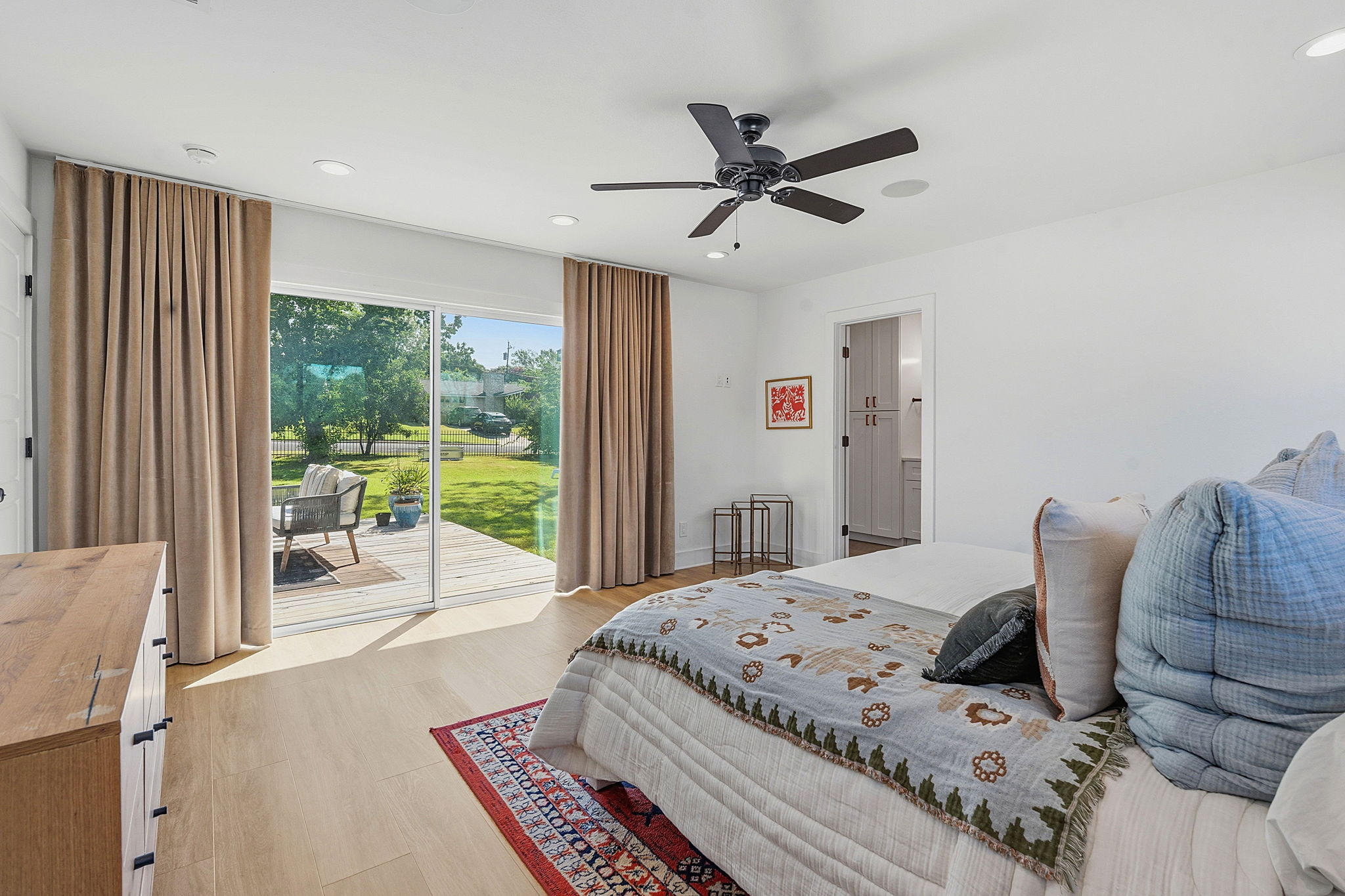 4403 Elmsgrove Drive Austin, TX 78721 - Photo 32 of 38 Step into a serene primary bedroom featuring warm wood flooring and direct deck access, perfect for enjoying peaceful outdoor moments.