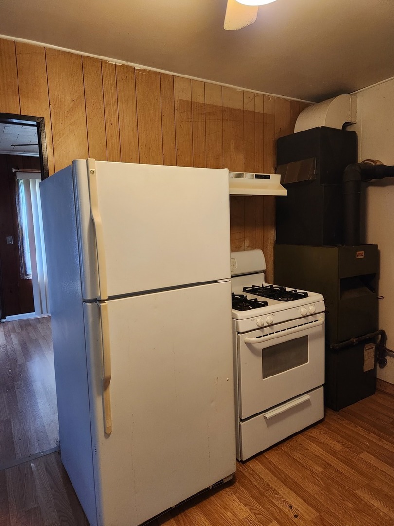 1228 20th Street North Chicago, IL 60064 - Photo 5 of 14 a white refrigerator freezer and a stove sitting inside of a kitchen