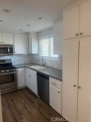 a kitchen with granite countertop white cabinets and white appliances