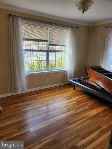 a room with wooden floor and windows