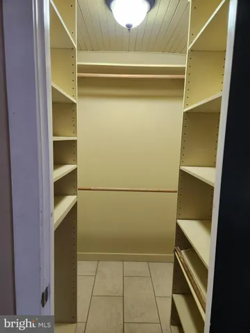 a view of walk in closet with empty racks