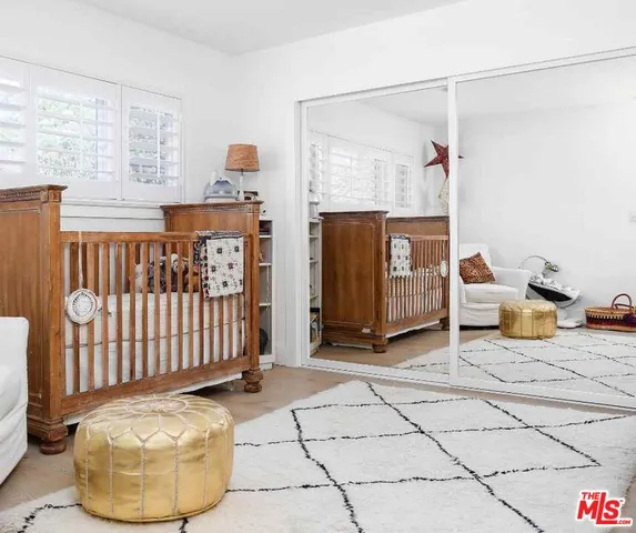 a living room with furniture and a baby crib
