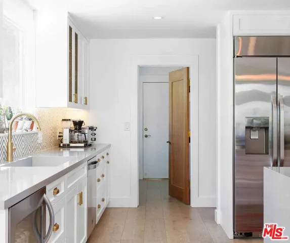 a view of white kitchen with a sink