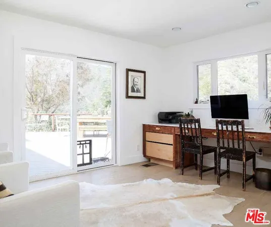 a view of a house with a small yard and potted plants
