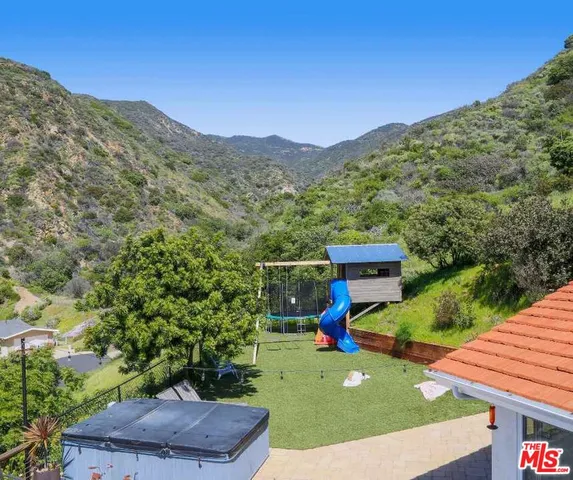 a roof deck with table and chairs and wooden floor