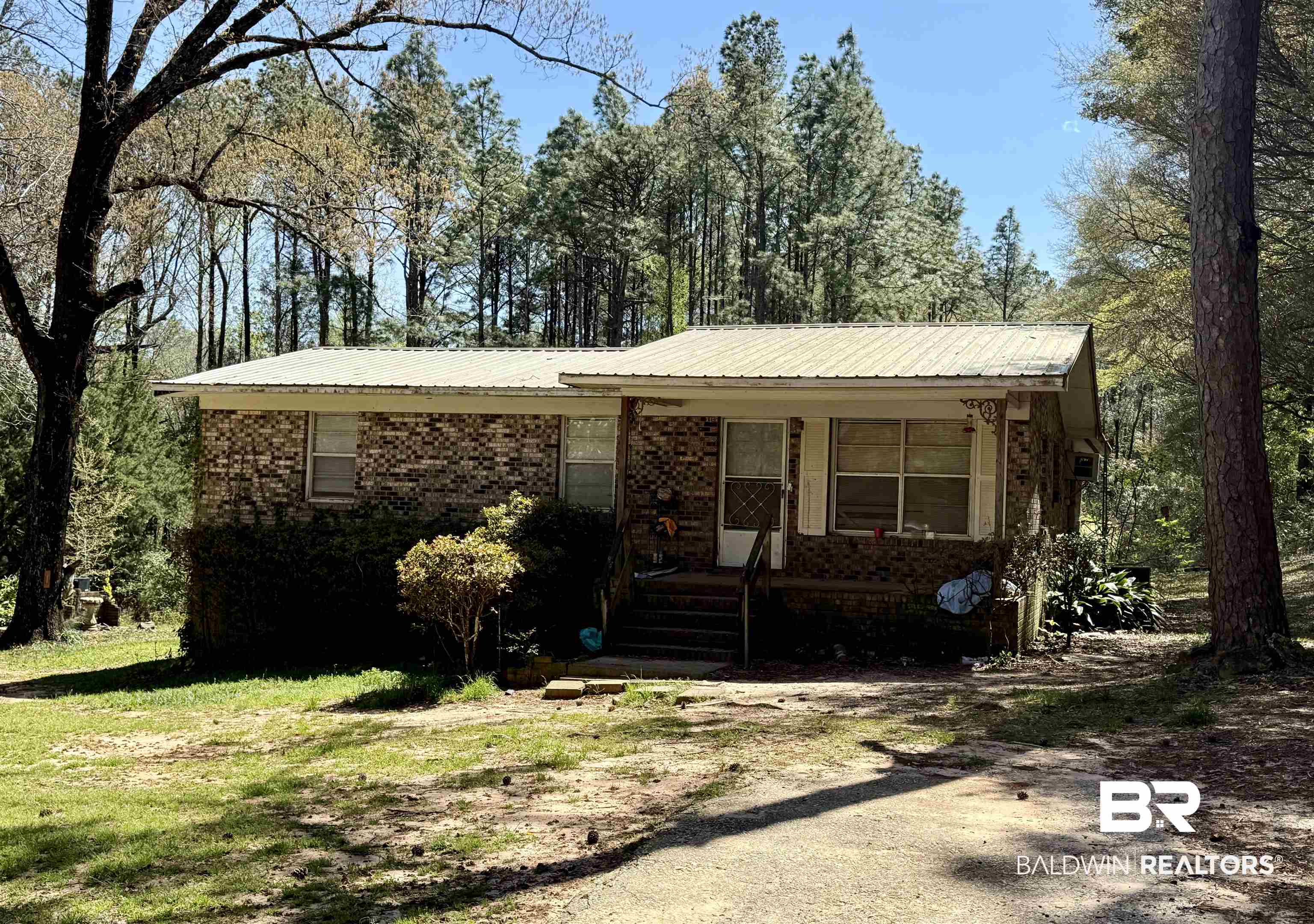 9801 Clebourne Road Wilmer, AL 36587 - Photo 1 of 3 Single story home with brick siding, metal roof, and a porch