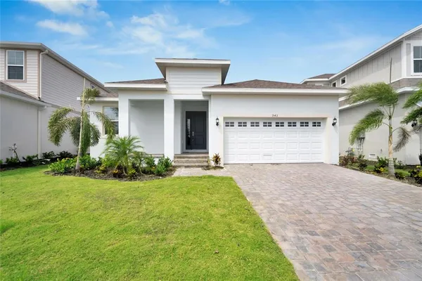 a front view of a house with a yard and garage