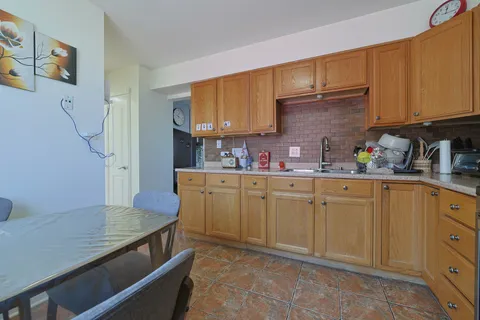 a kitchen with granite countertop a refrigerator stove and sink