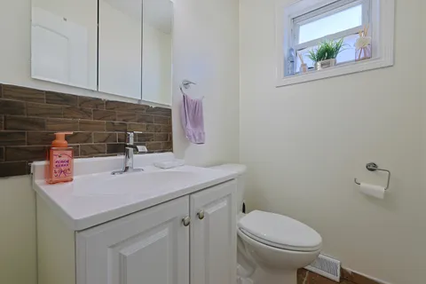a bathroom with a sink vanity and toilet