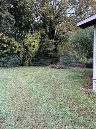 a view of an empty room with a fireplace and a window