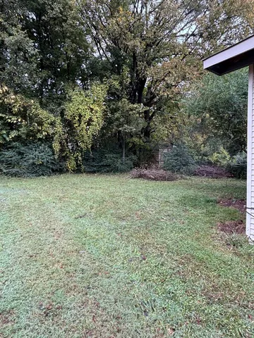 a view of an empty room with a fireplace and a window