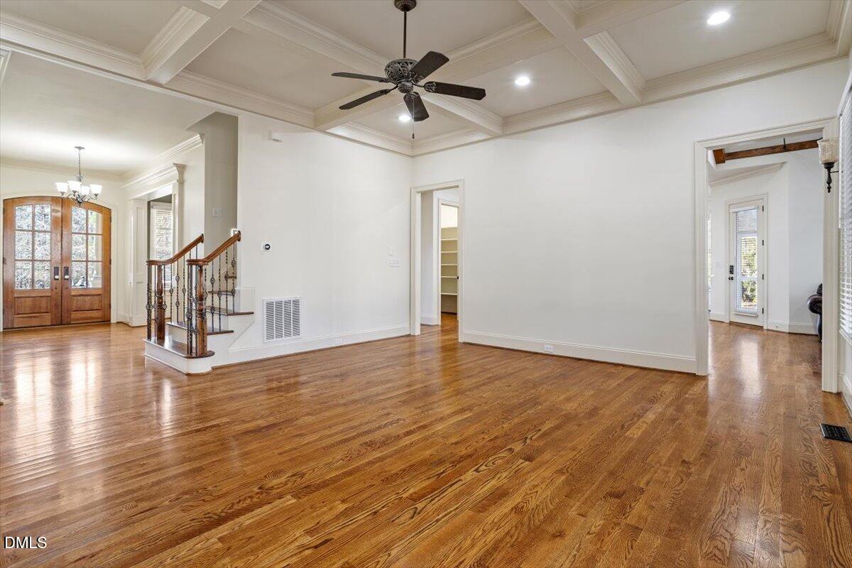 12820 River Dance Drive Raleigh, NC 27613 - Photo 10 of 86 a view of an empty room with wooden floor and a ceiling fan