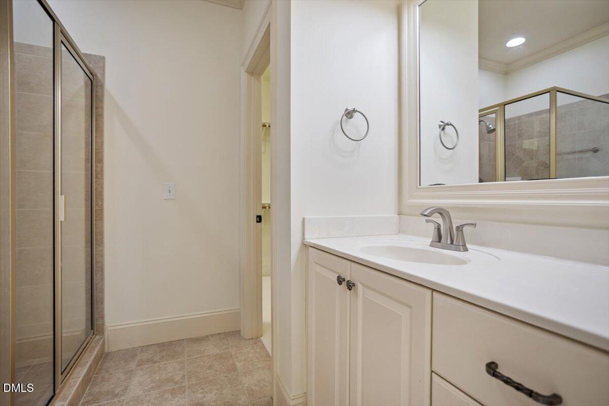 12820 River Dance Drive Raleigh, NC 27613 - Photo 41 of 86 a bathroom with a granite countertop sink and a mirror