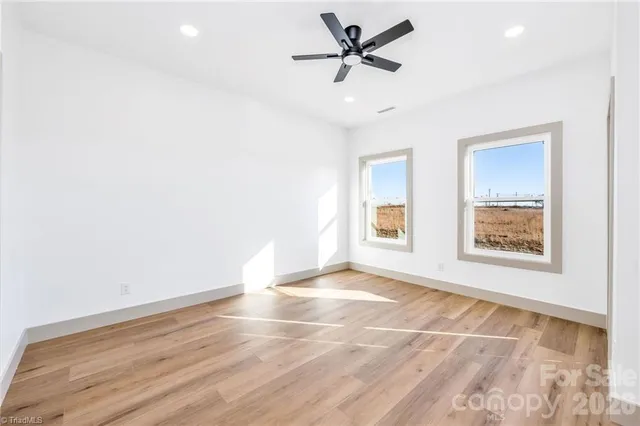 a view of an empty room with a window and a ceiling fan