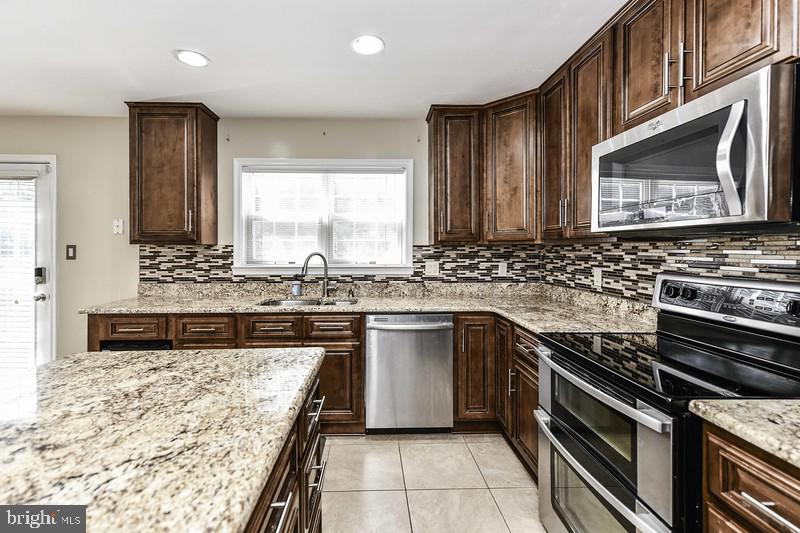2 Parker Farm Court Silver Spring, MD 20906 - Photo 21 of 34 a kitchen with stainless steel appliances granite countertop a stove a sink and a microwave