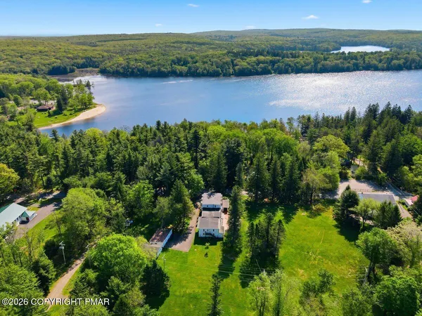 an aerial view of a house with a garden and lake view