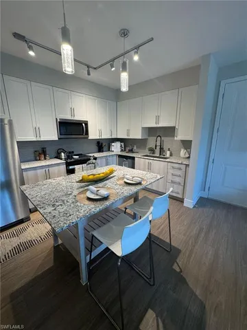 a kitchen with a table chairs microwave and cabinets