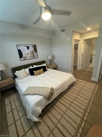 a bedroom with a bed and a painting on the wall