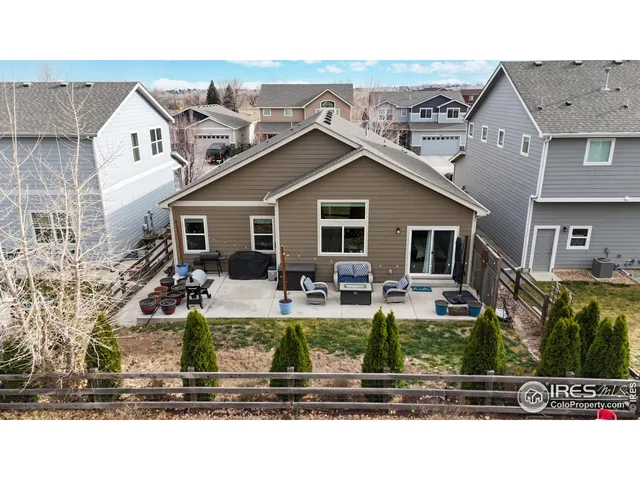 a front view of house with yard outdoor seating and covered with tall trees