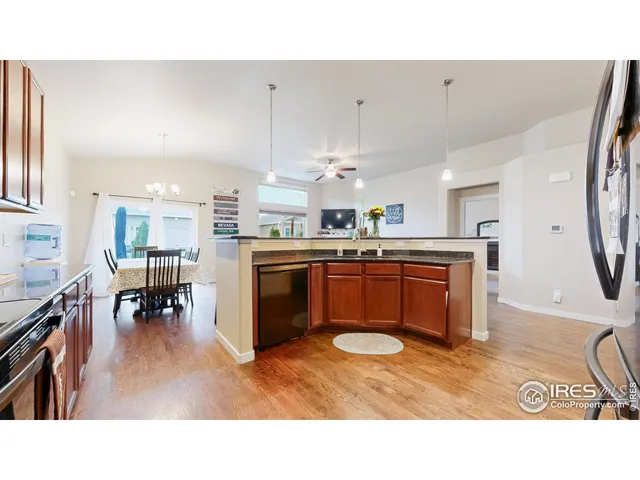 a kitchen with stainless steel appliances kitchen island granite countertop a stove a sink a dining table and chairs