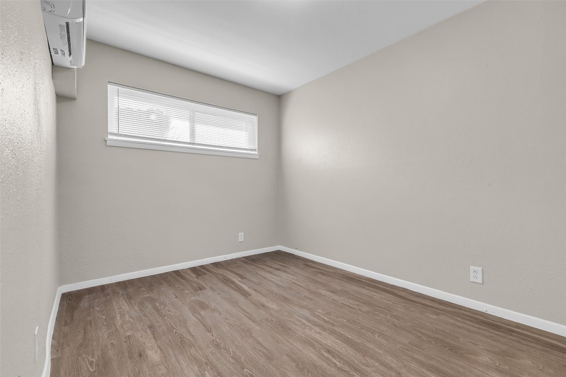 4706 Yellowstone Boulevard, Unit 11 Houston, TX 77021 - Photo 8 of 13 an empty room with wooden floor and windows