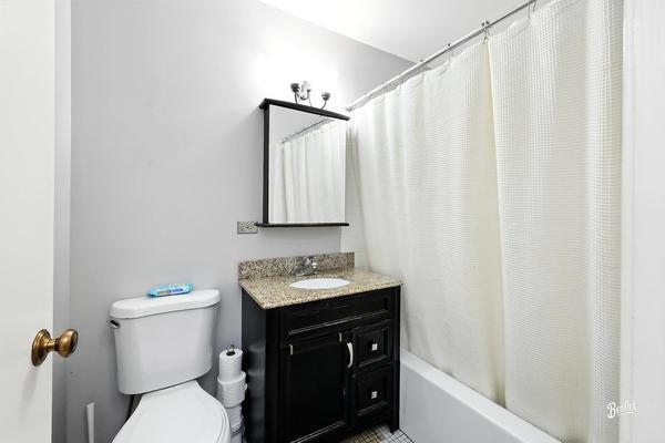 1425 Sandpebble Drive, Unit 340 Wheeling, IL 60090 - Photo 5 of 14 a bathroom with a sink a toilet and shower curtain