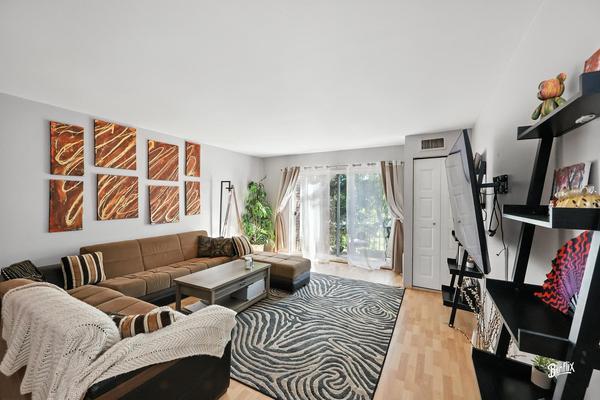 1425 Sandpebble Drive, Unit 340 Wheeling, IL 60090 - Photo 7 of 14 a living room with furniture and a flat screen tv